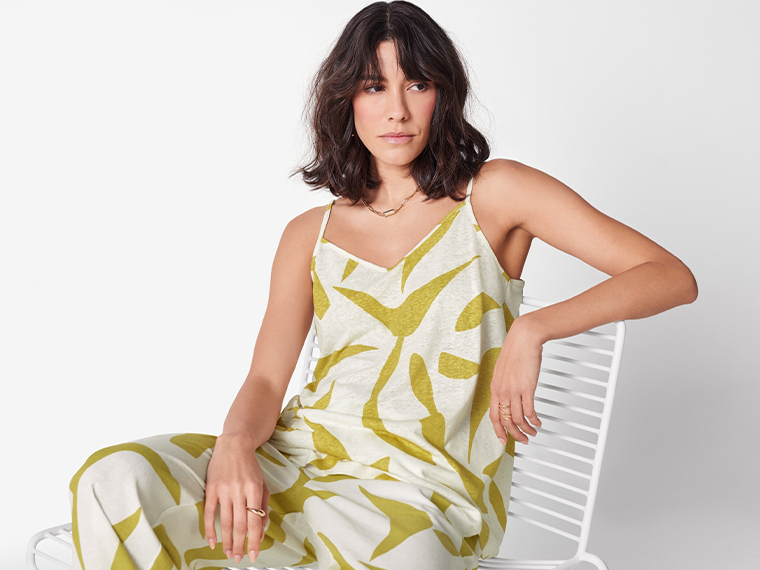 Une femme porte un ensemble coordonné imprimé de couleur vert olive et blanc cassé.