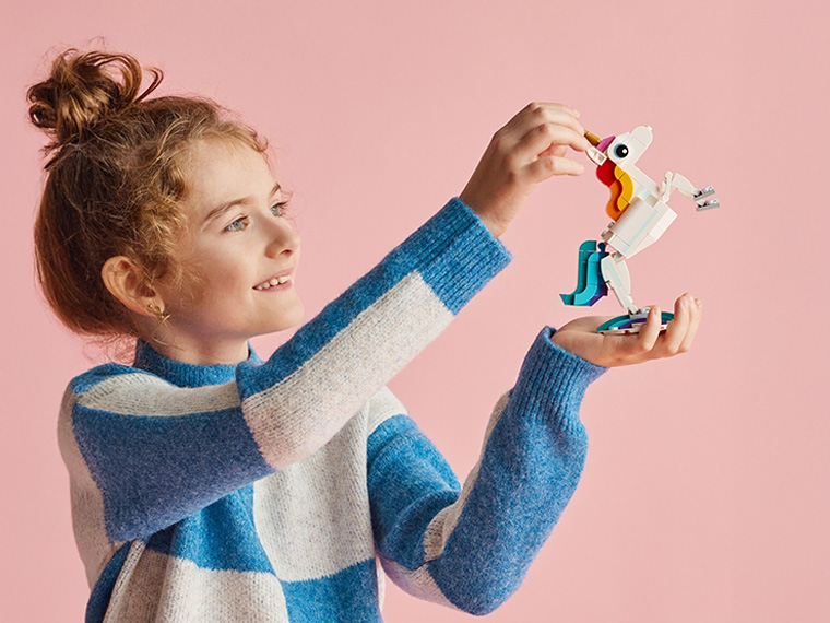 Une fillette joue avec un jouet LEGO licorne.