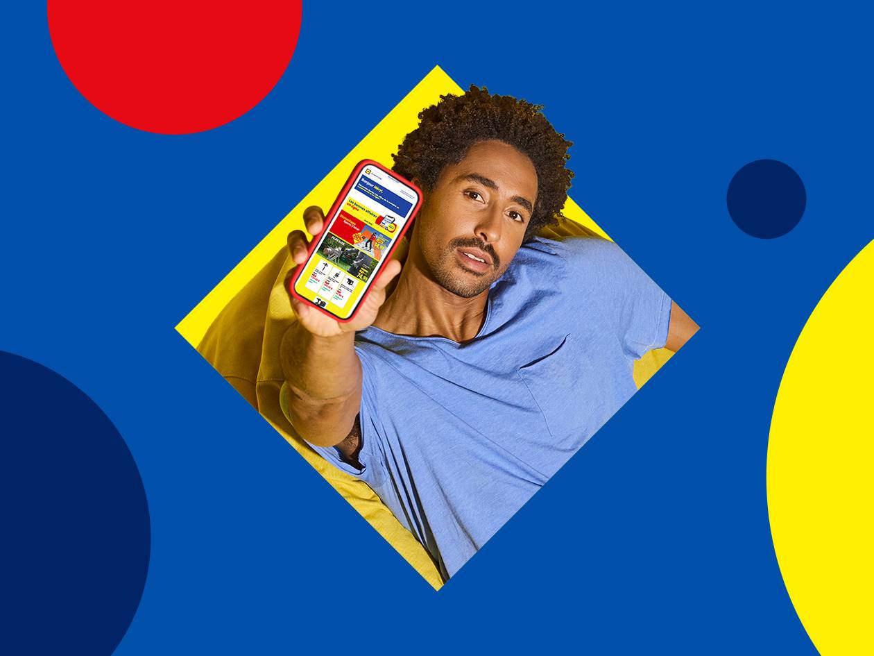 Homme souriant montrant un smartphone avec des offres de jardinage et de bricolage.