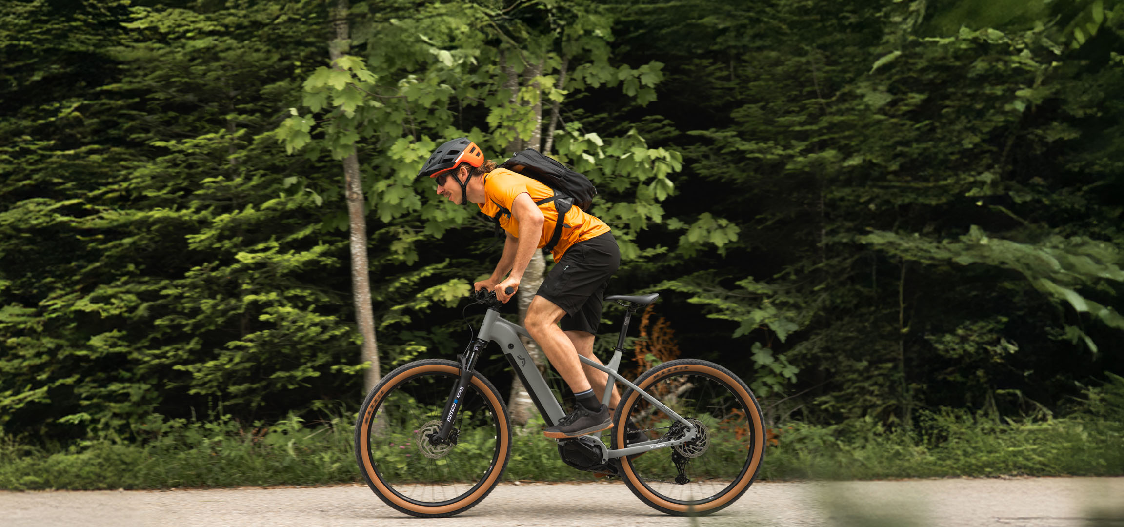 Un homme fait du vélo sur une bicyclette électrique Cube dans une forêt.