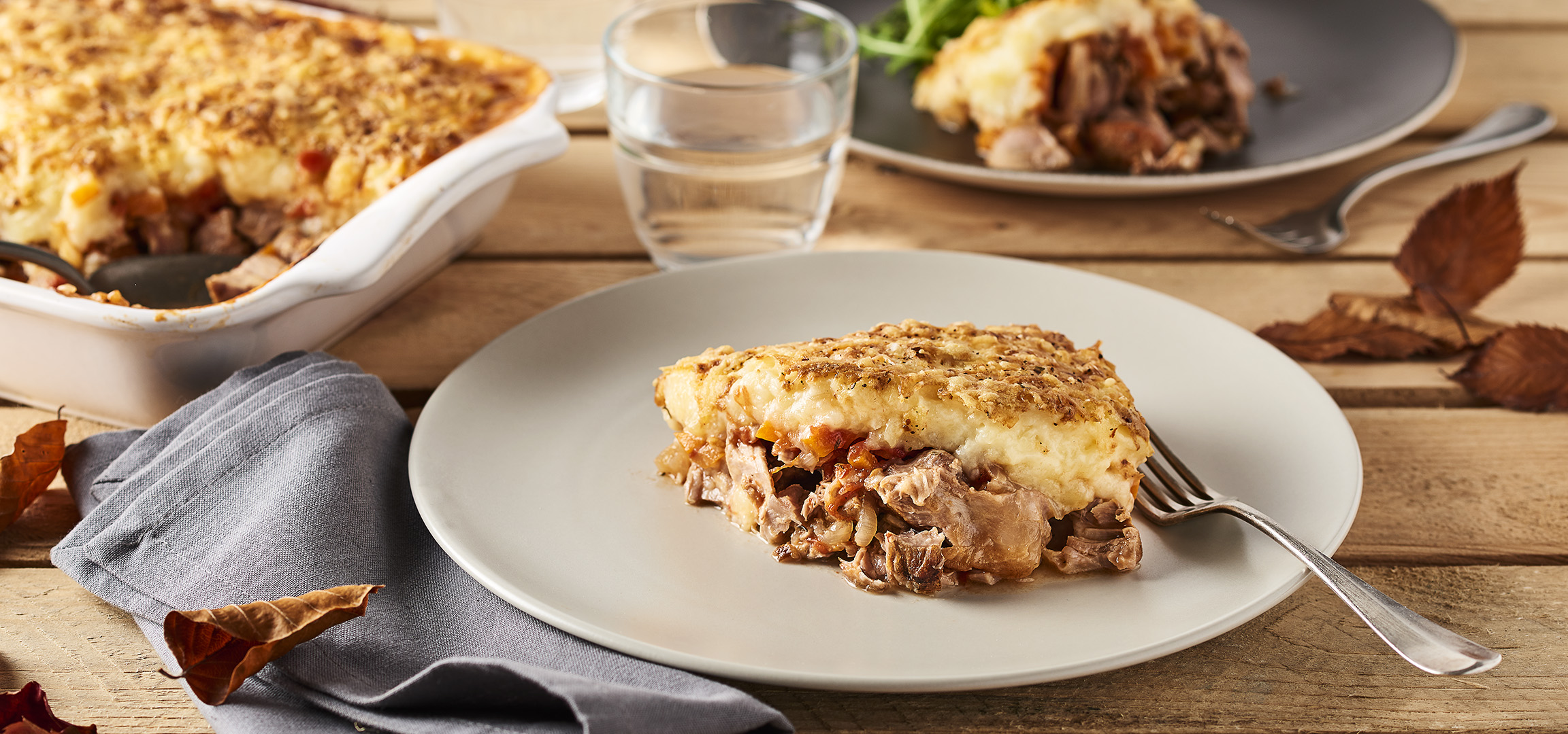 Plat de hachis Parmentier avec de la viande et des légumes, servi sur une table en bois.