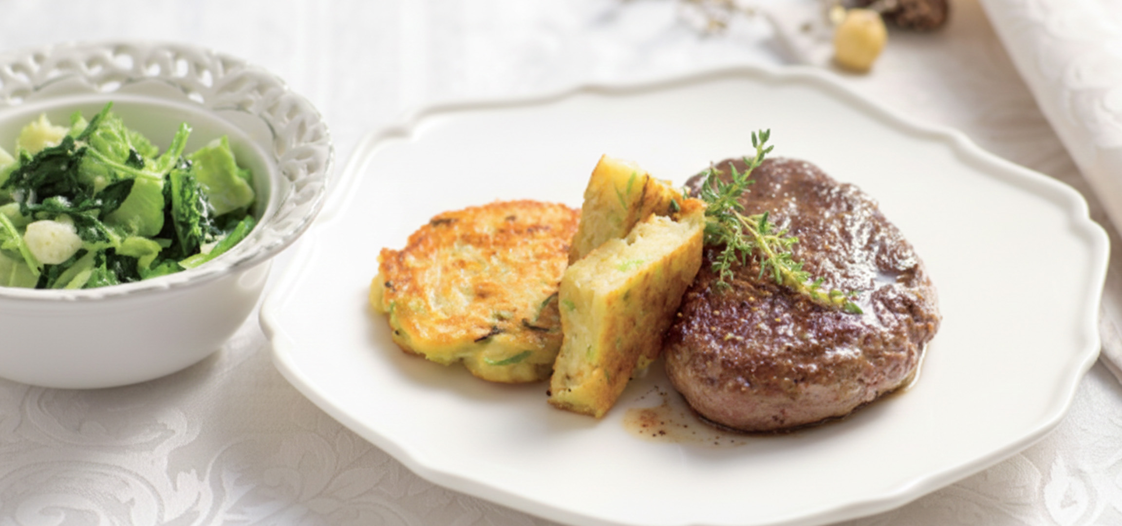 Steak de bœuf avec galettes de pommes de terre et salade verte.