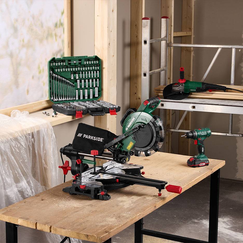 Outils électriques et jeu de clés dans un atelier de menuiserie.