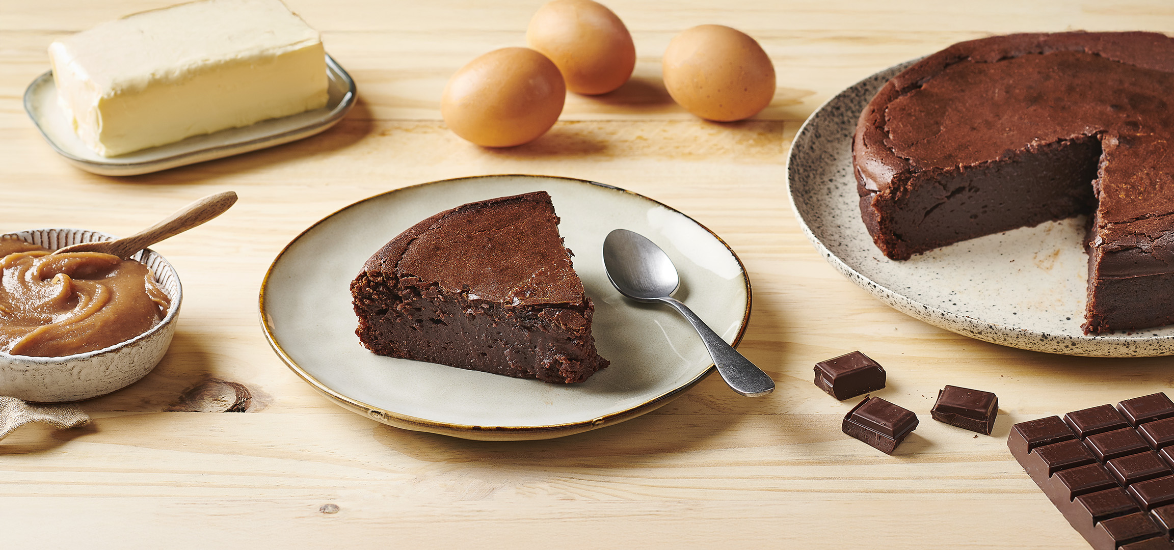 Gâteau au chocolat avec une part coupée, sauce caramel, beurre, œufs et chocolat.