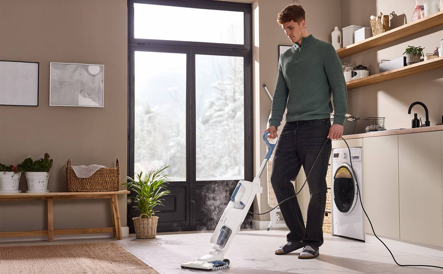 Un homme nettoie le sol avec un nettoyeur vapeur dans une buanderie moderne.