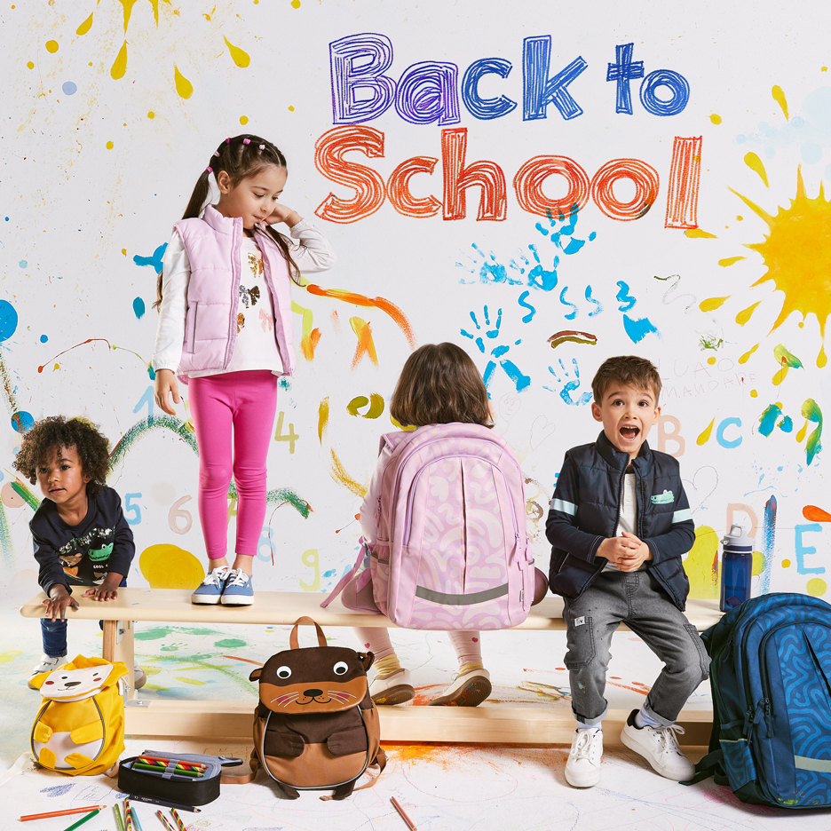 Quatre enfants avec des sacs à dos et des fournitures scolaires, avec le texte 'Back to School' sur un fond coloré.