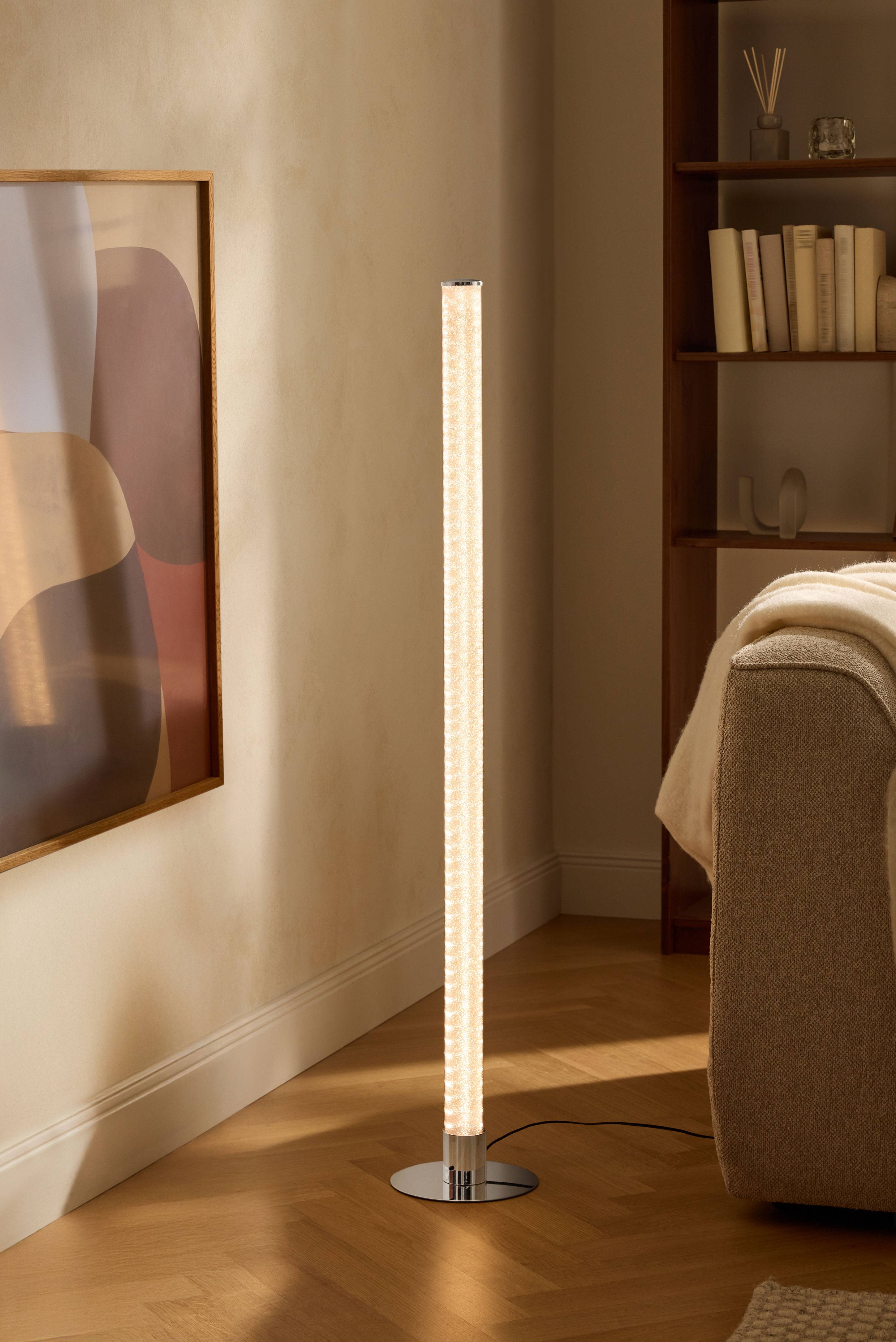 Lampadaire moderne dans un salon avec étagère et canapé.