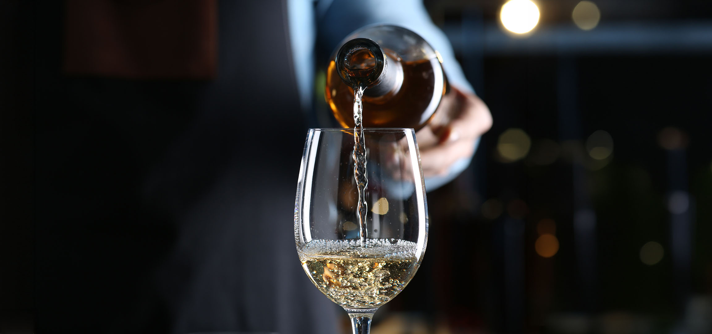 Du vin blanc est versé dans un verre.