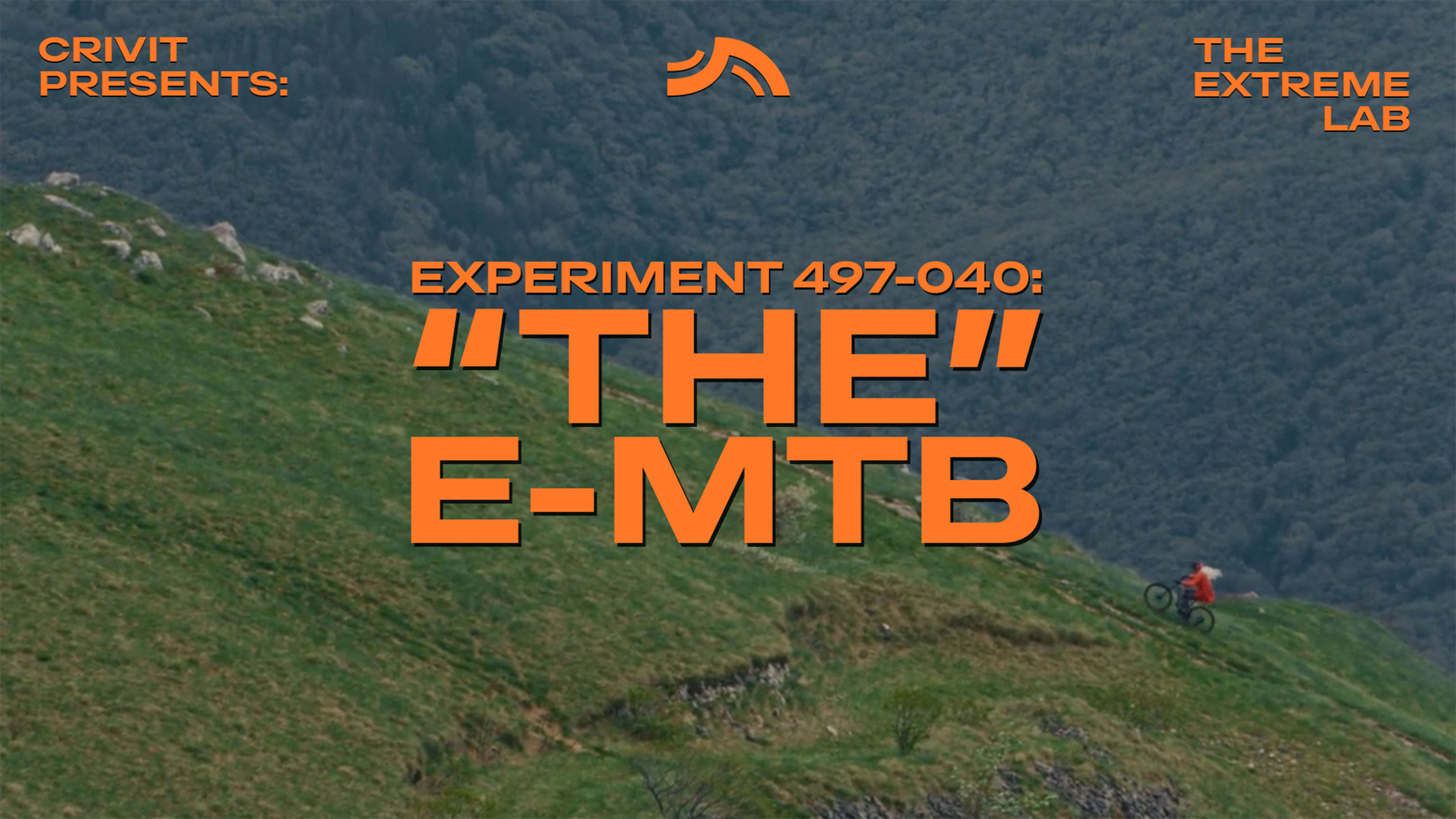 Cycliste de montagne sur une pente herbeuse, avec le texte 'THE E-MTB' et 'THE EXTREME LAB'.