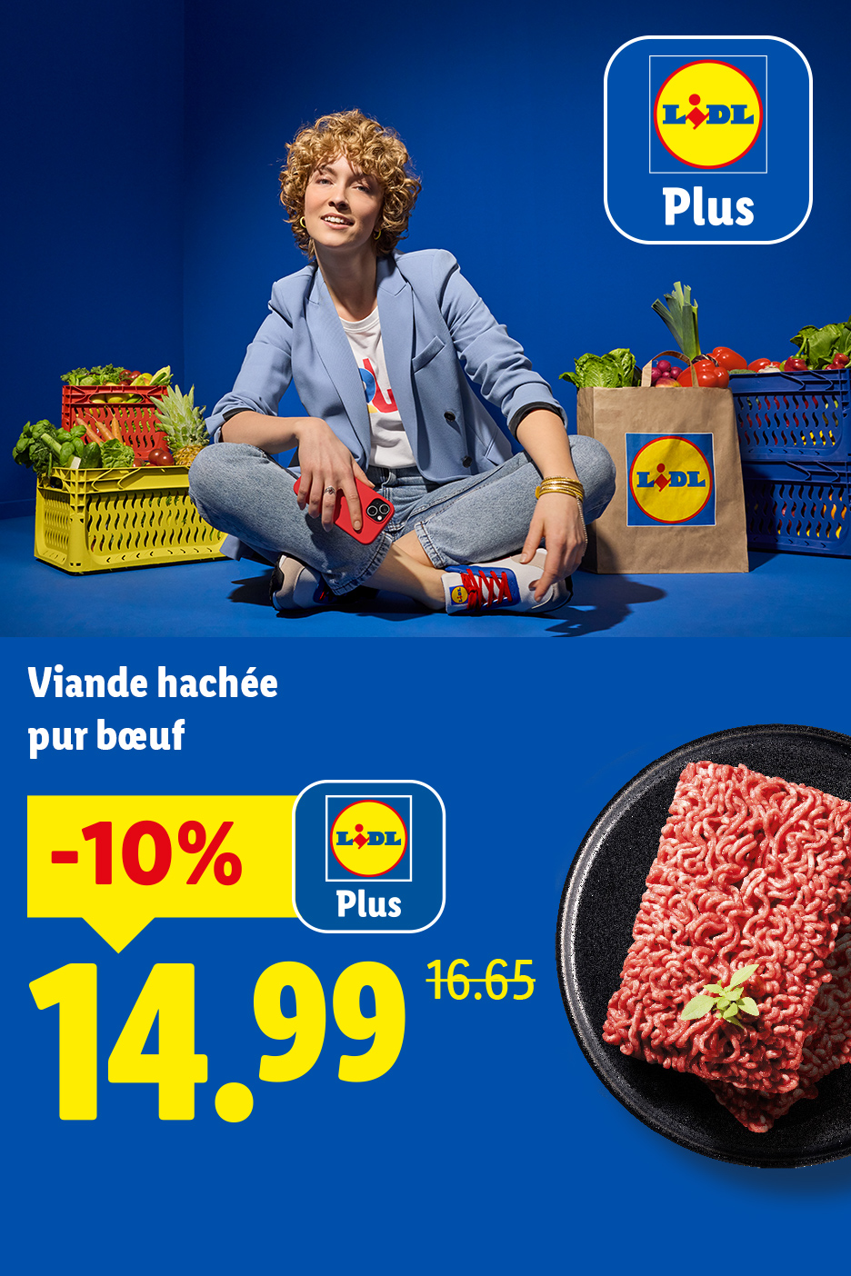 Une femme souriante assise parmi des caisses de légumes, avec de la viande hachée en promotion.