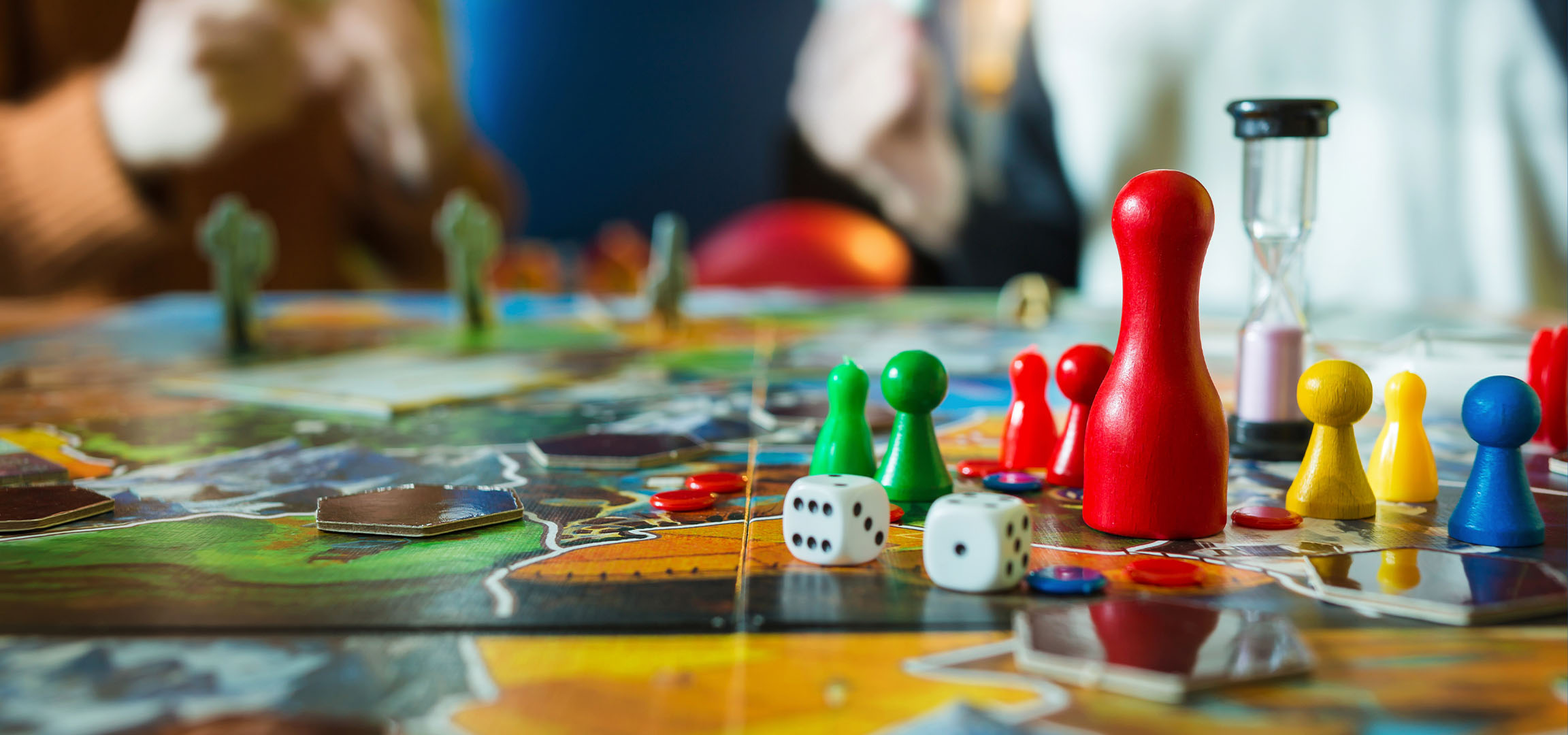 Pièces de jeu de société colorées, y compris des pions rouges, verts, jaunes et bleus, avec des dés.