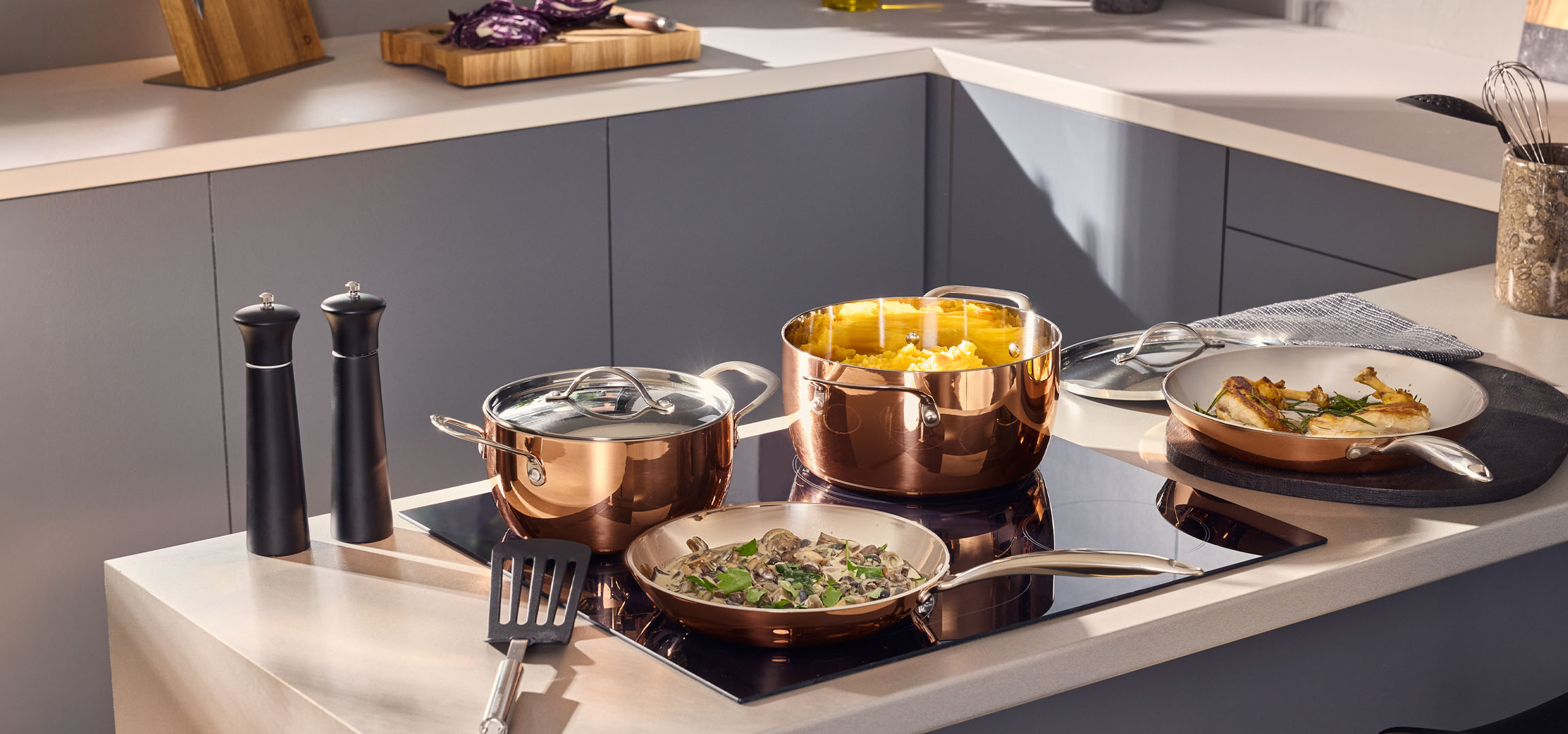 aiLabeling.aiLabelForImageAltText: Casseroles et poêles couleur cuivre avec de la nourriture sur une plaque à induction.