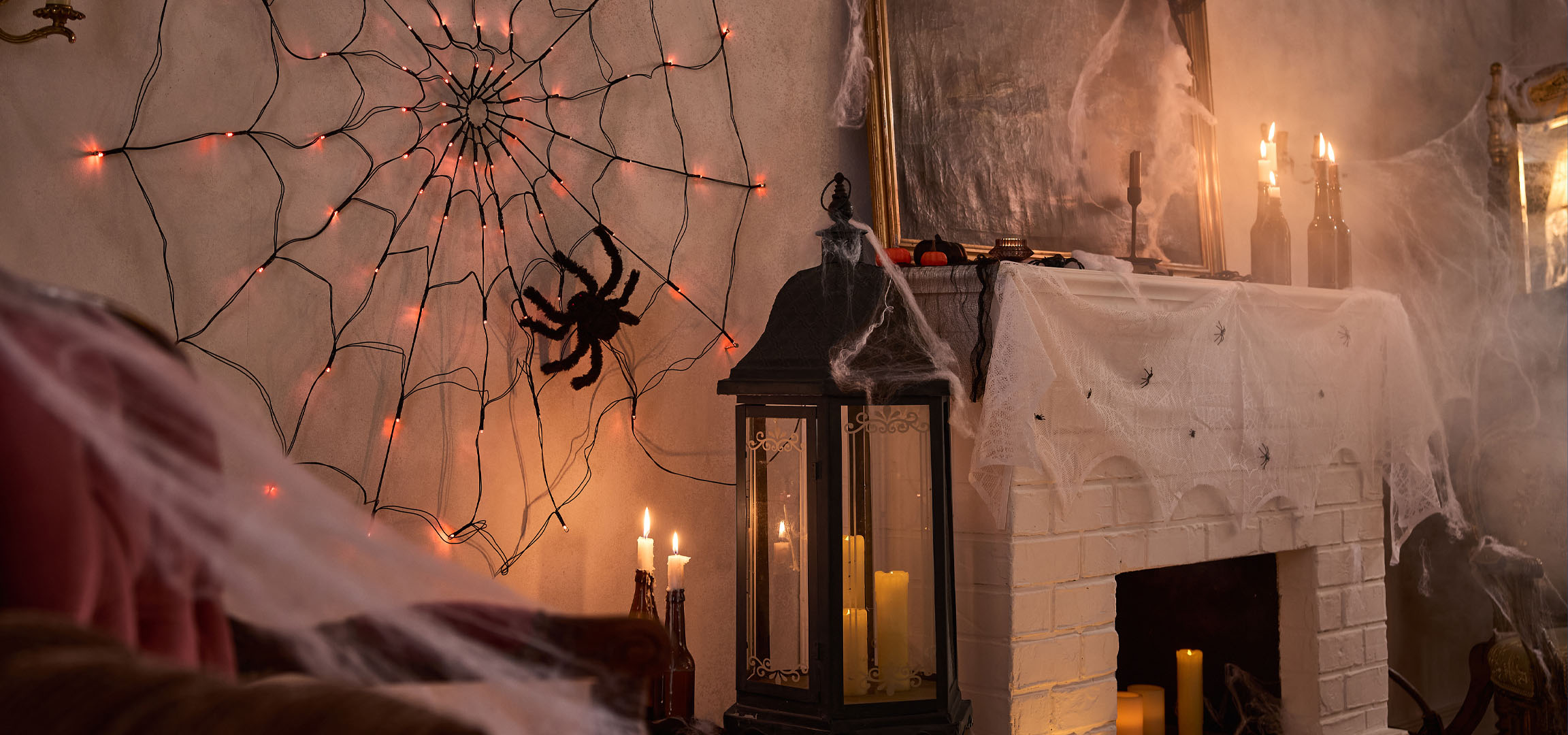 Décorations d'Halloween avec des lumières toile d'araignée, une grande araignée et des bougies.