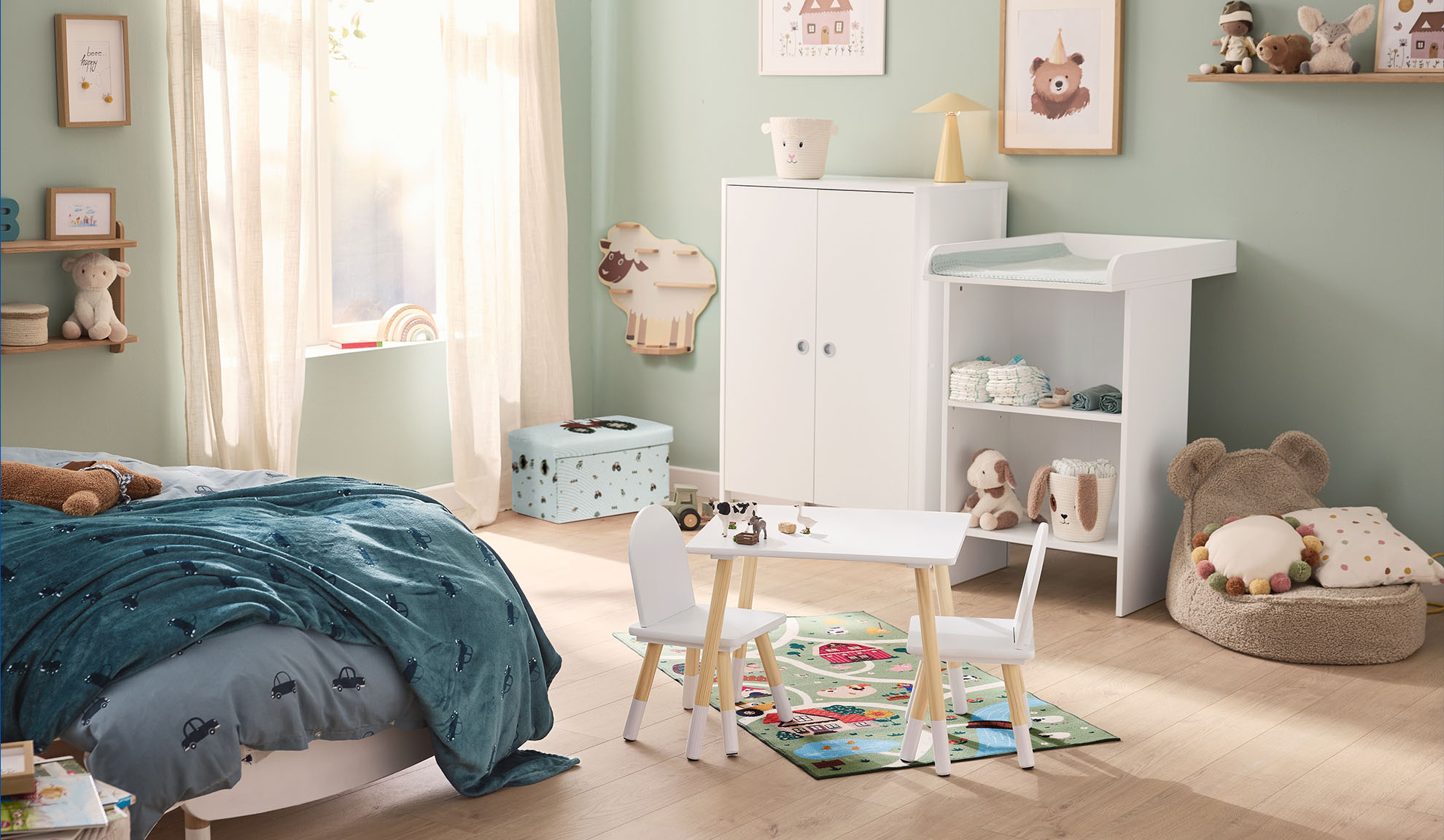 Chambre d'enfant avec lit, table à langer, armoire et table de jeu avec chaises.
