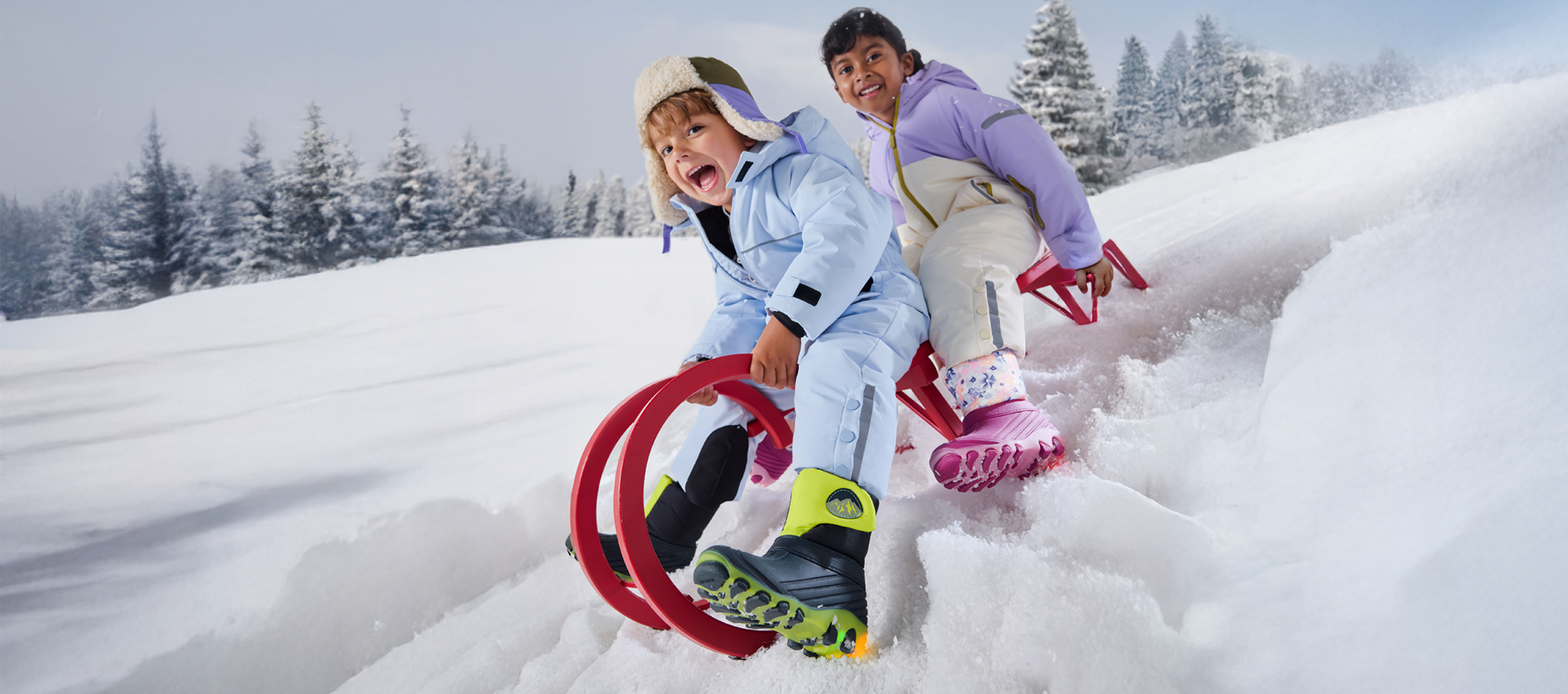Deux enfants en combinaisons de neige et bottes d'hiver, faisant de la luge sur une pente enneigée.