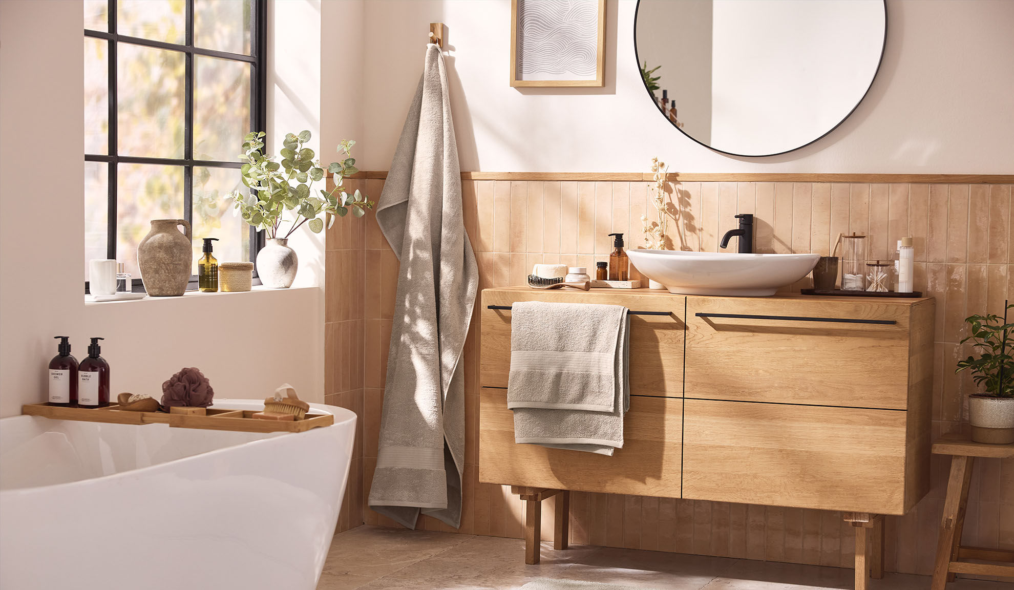 Salle de bain moderne avec meubles de salle de bain en bois, une baignoire et une fenêtre.