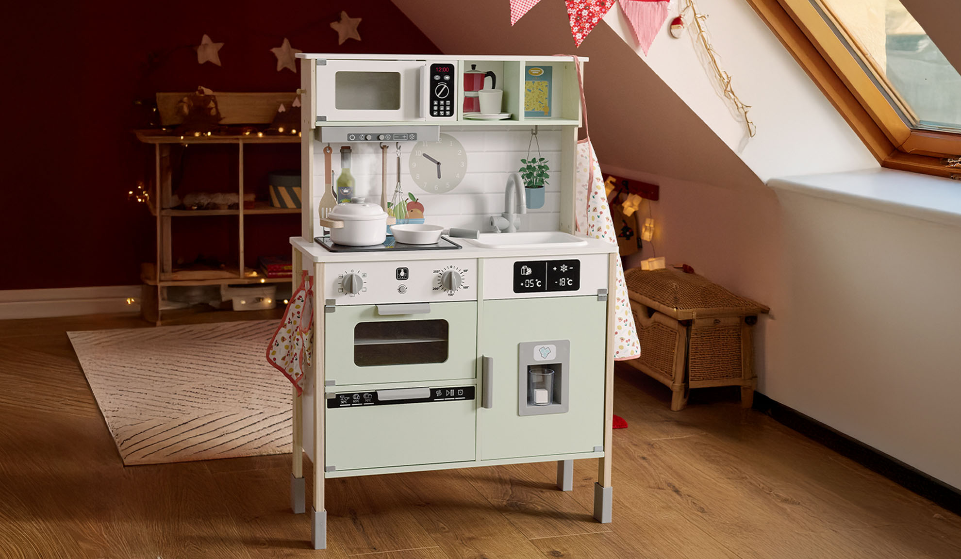 Cuisine de jeu en bois avec micro-ondes, four et réfrigérateur dans une chambre mansardée.