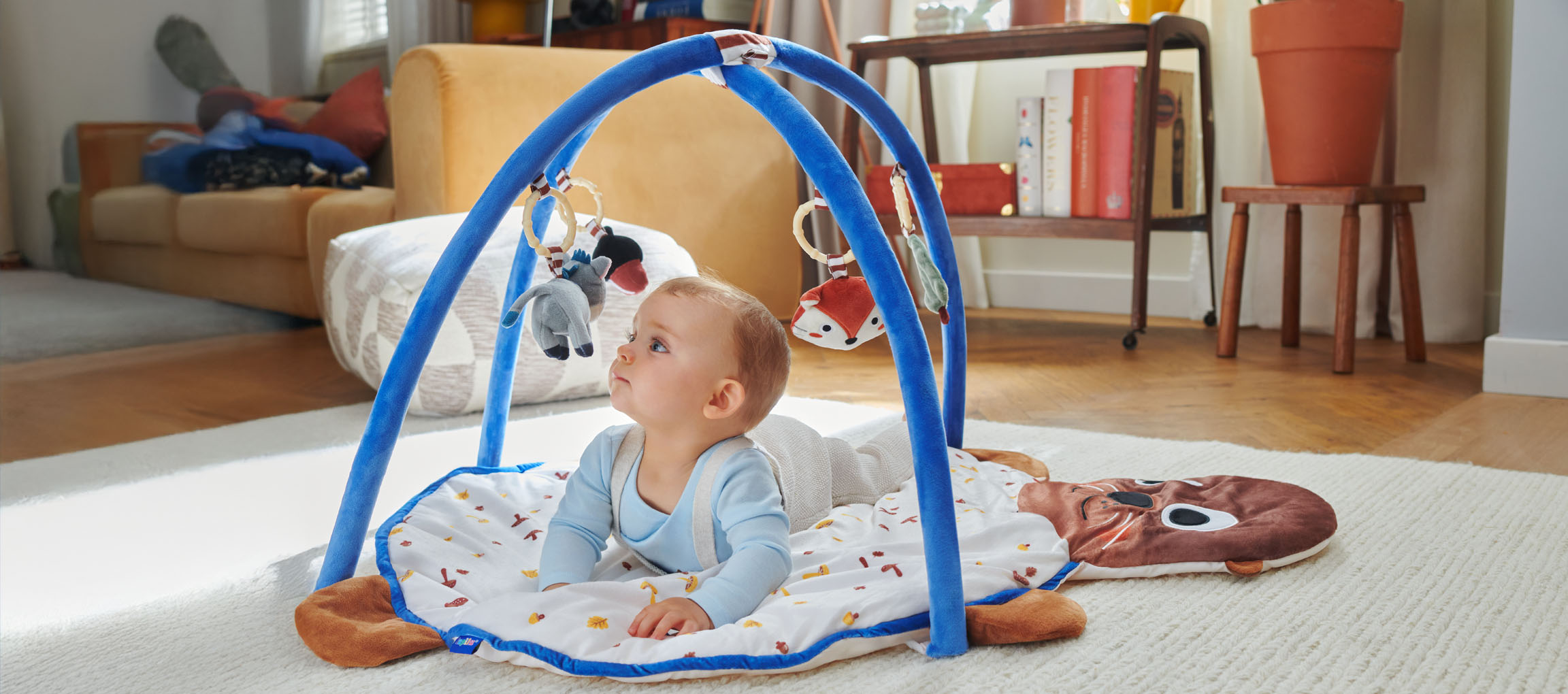Un bébé joue avec un tapis d'éveil Little Dutch en forme de phoque.