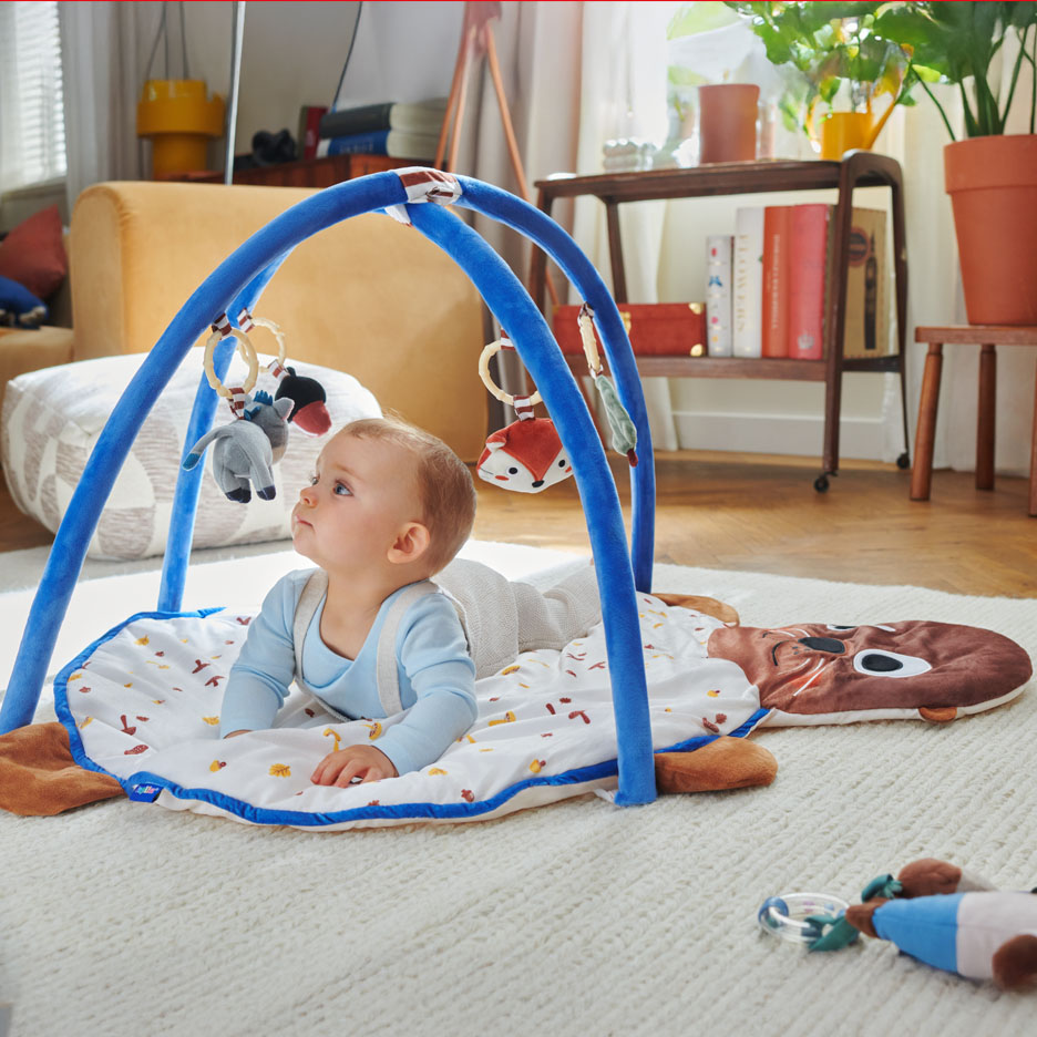 Bébé jouant sur un tapis d'éveil Little Dutch avec arche.
