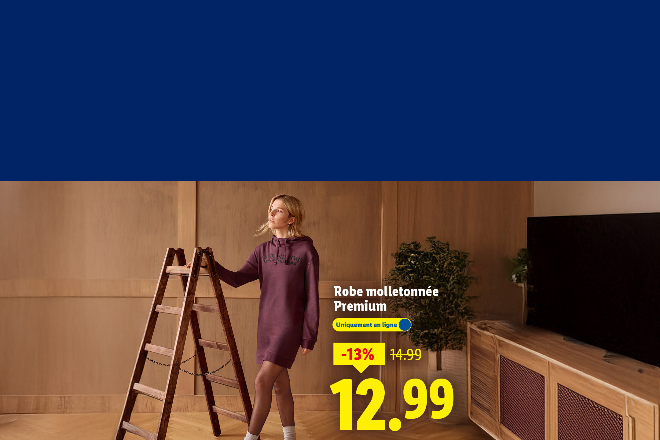 Une femme en robe molletonnée Premium, avec une réduction de 13% à 12,99€.