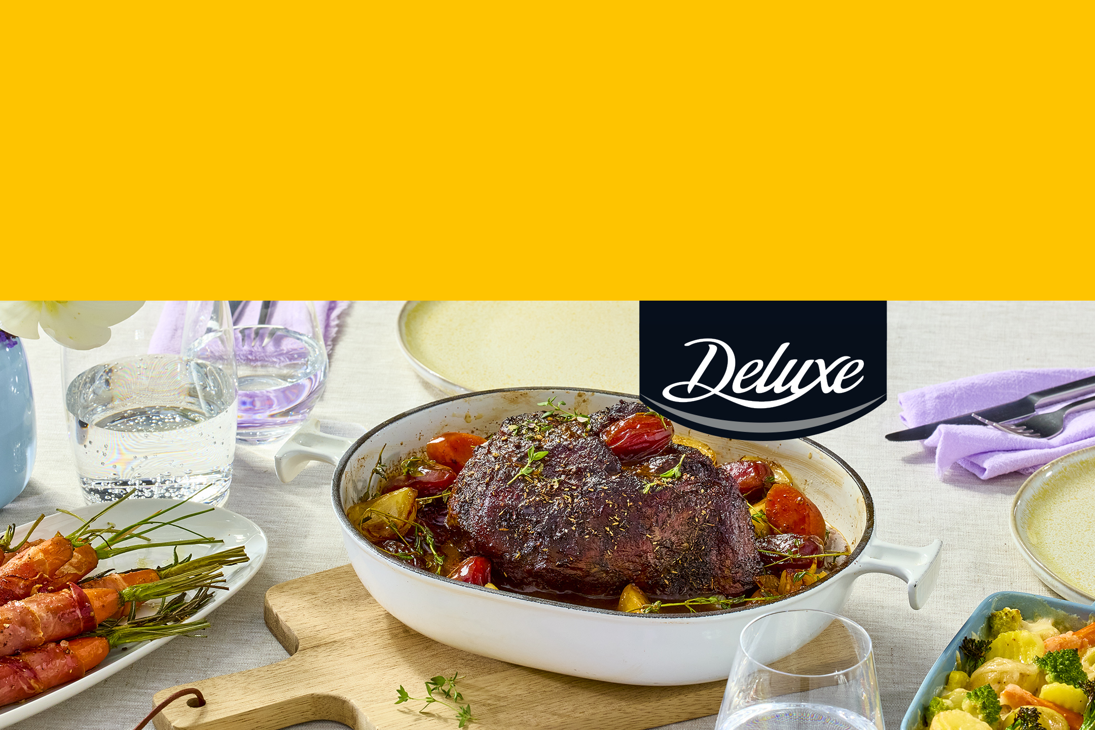 Rôti de bœuf avec des légumes dans un plat de cuisson, servi sur une table dressée.