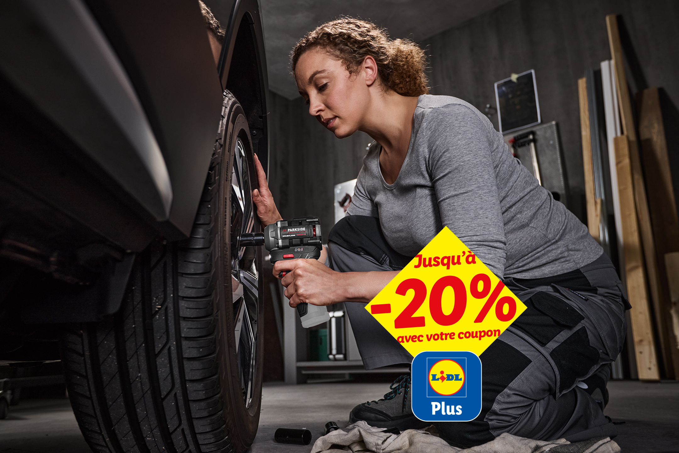 Une femme utilise une visseuse à chocs sur un pneu de voiture, avec une offre de -20%.