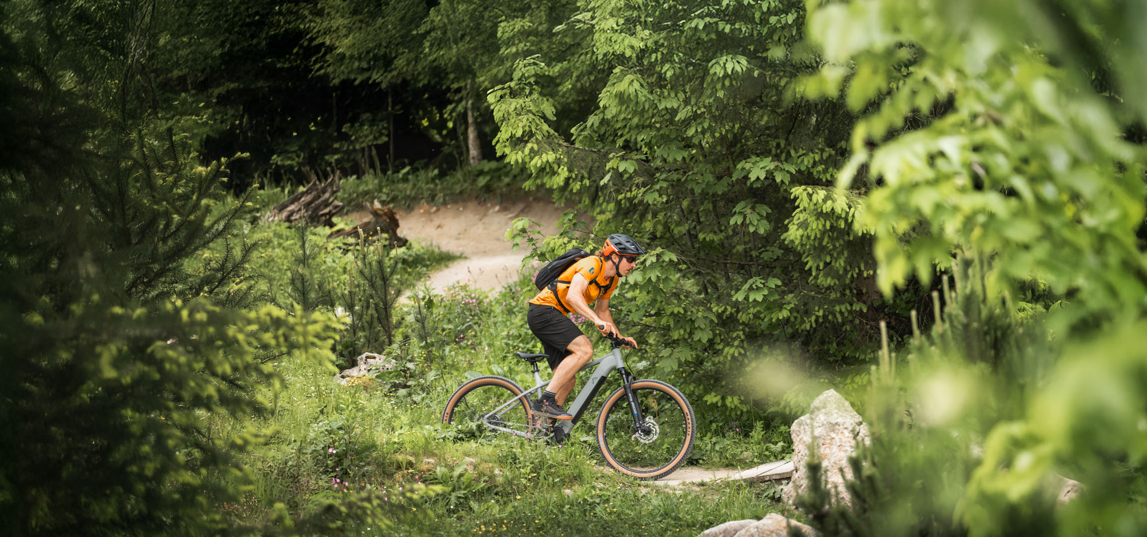 Un cycliste profite d'une balade à vélo électrique sur un sentier forestier.