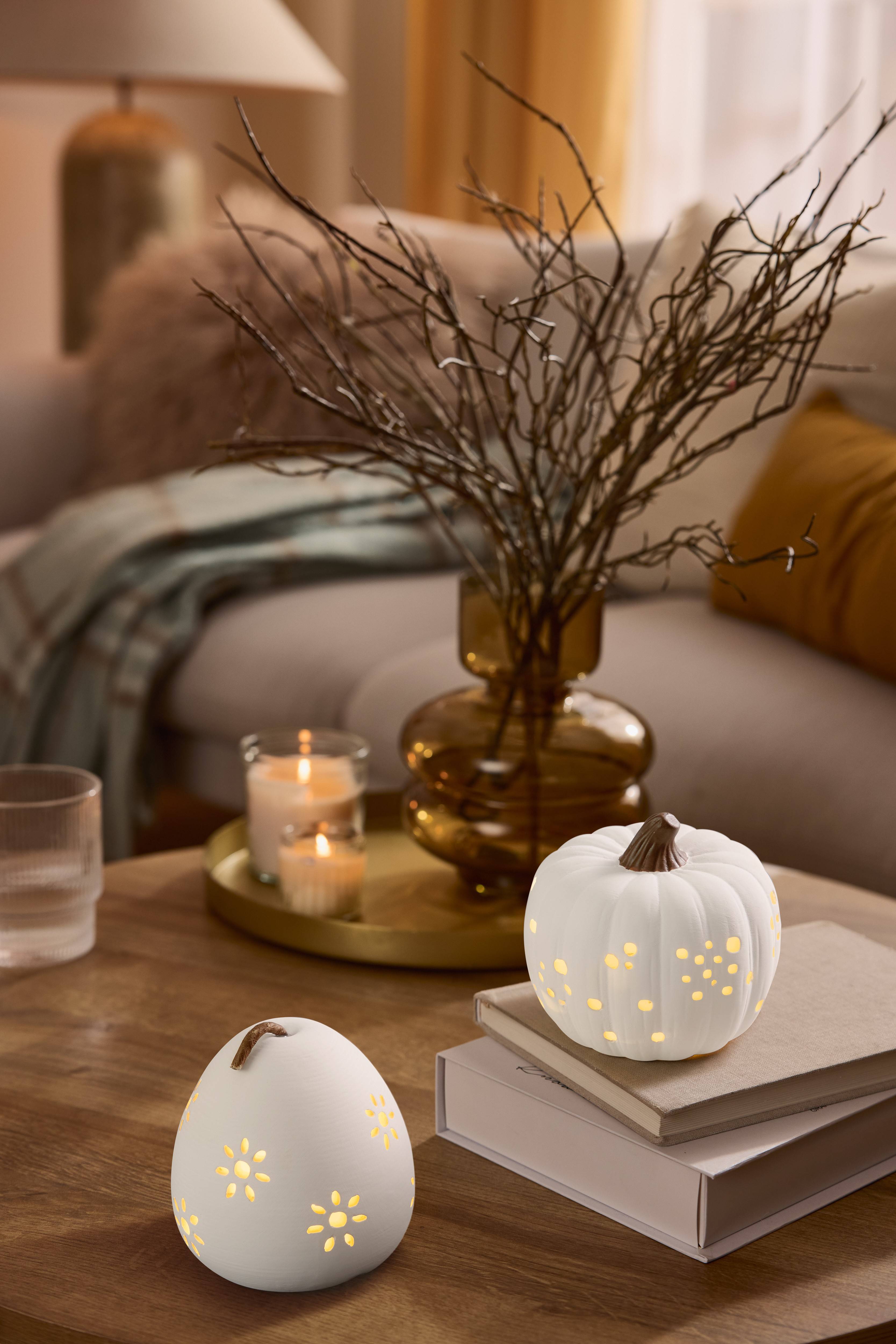 Décorations lumineuses en forme de citrouille et de poire sur une table basse en bois.