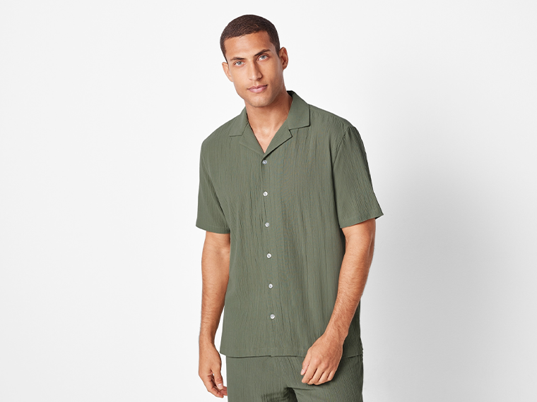 Un homme porte une chemise et un short assortis vert olive.