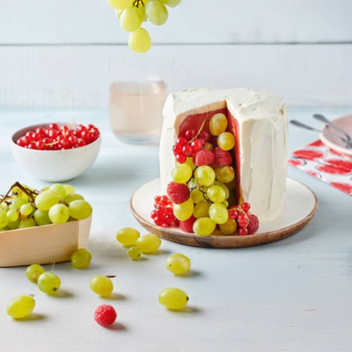 Gâteau au fromage blanc fourré de fruits rouges et raisins verts.