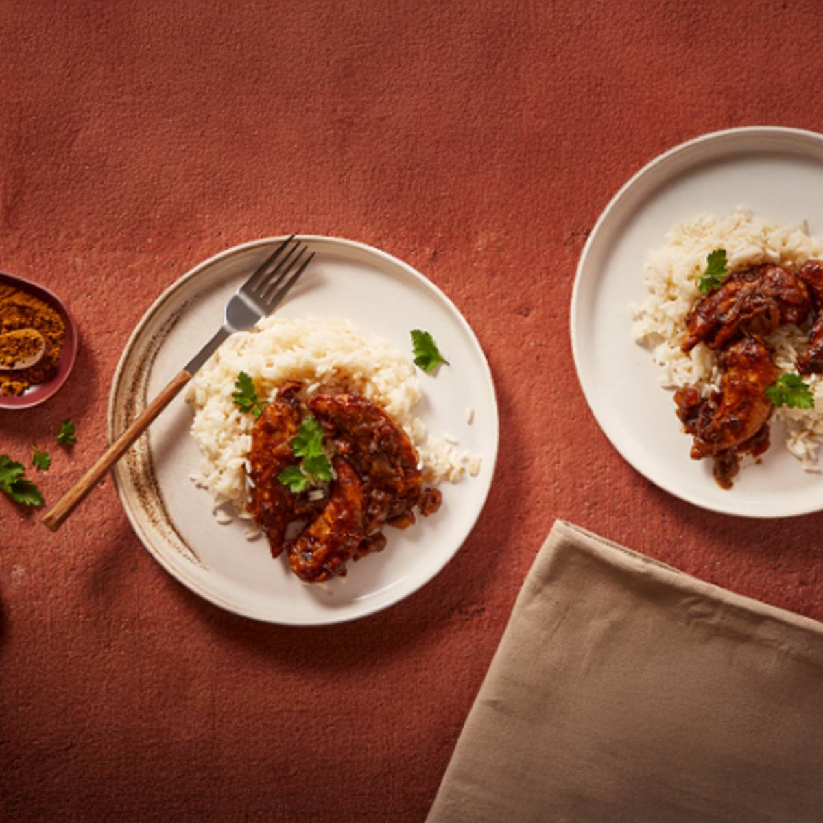 Deux assiettes de poulet au curry servi avec du riz.