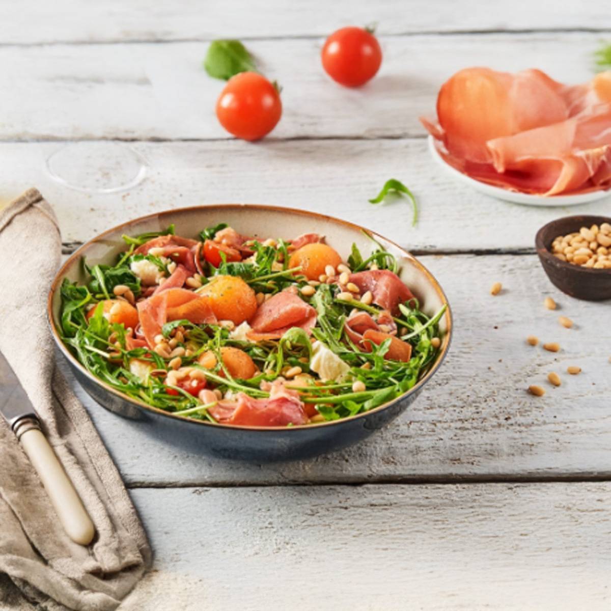 Salade estivale rafraîchissante avec melon, jambon cru, roquette et pignons de pin.