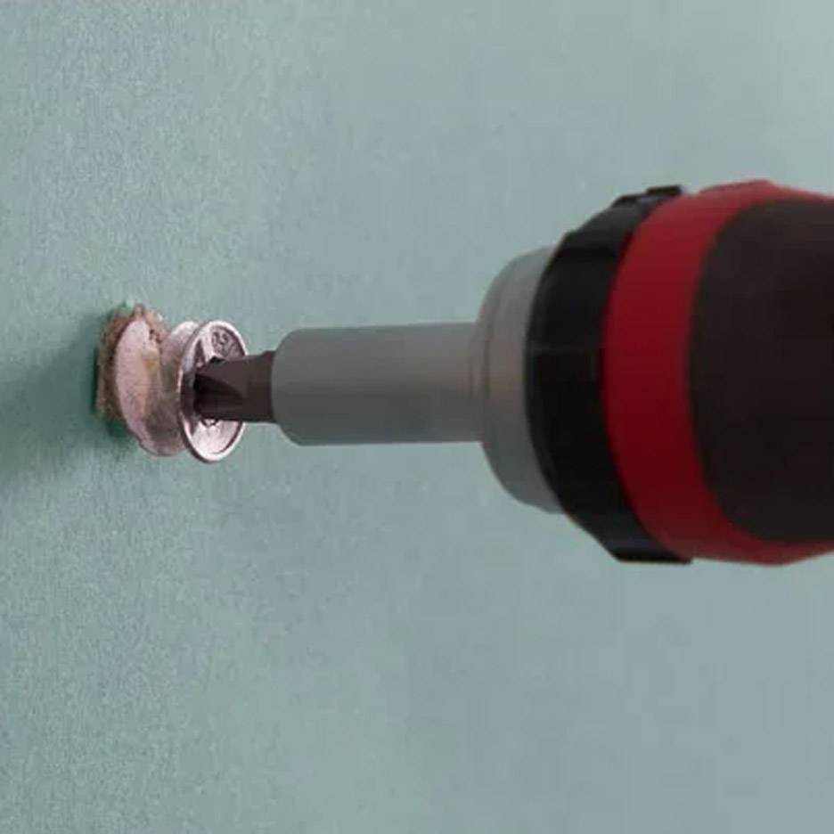 Tournevis électrique avec embout de perçage insérant une vis dans le mur.