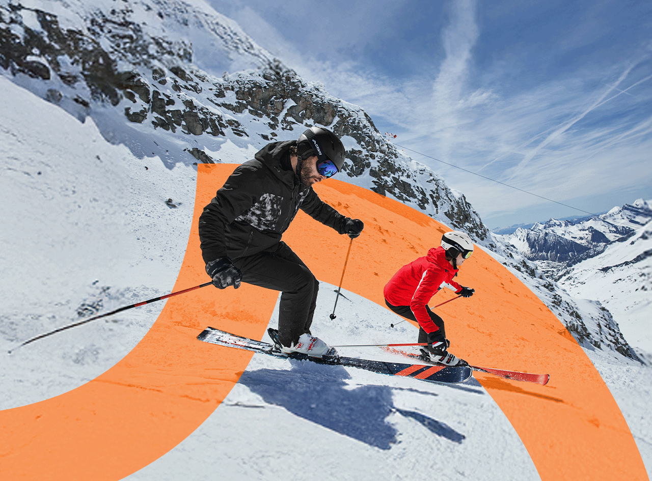 Deux skieurs, un homme et une femme, dévalent une piste de ski en montagne.